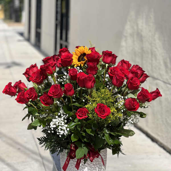 Bouquet of red roses with a sunflower in a silver vase