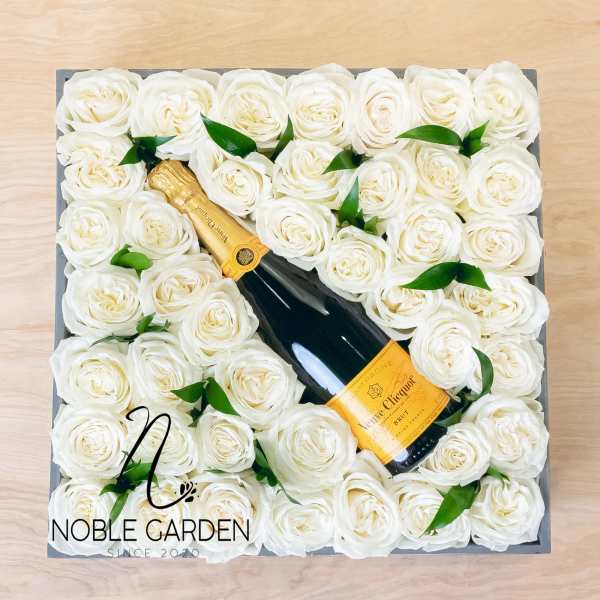 Box of white roses with a champagne bottle in the center