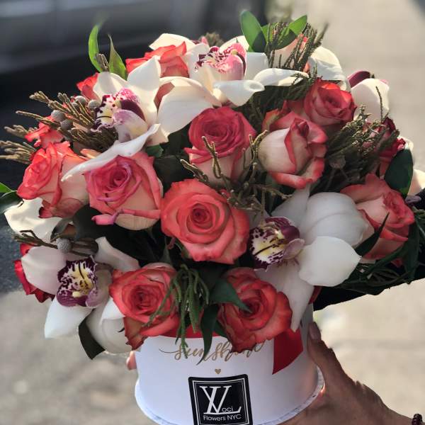 Bouquet of pink roses and white orchids in a white hat box