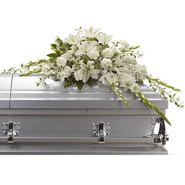 White floral casket spray on a silver casket