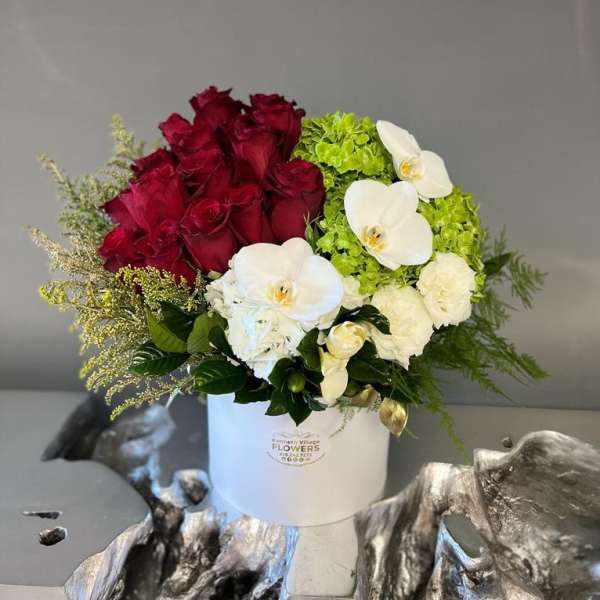 Bouquet of red roses and white orchids in a white hat box