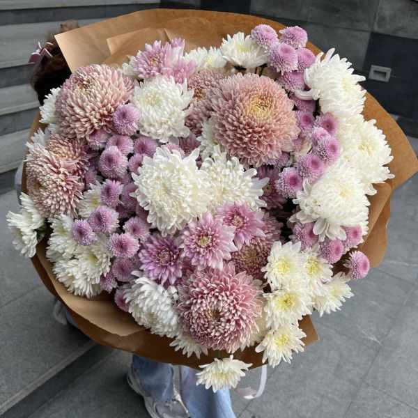Large bouquet of pink, white, and lavender chrysanthemums wrapped in brown paper