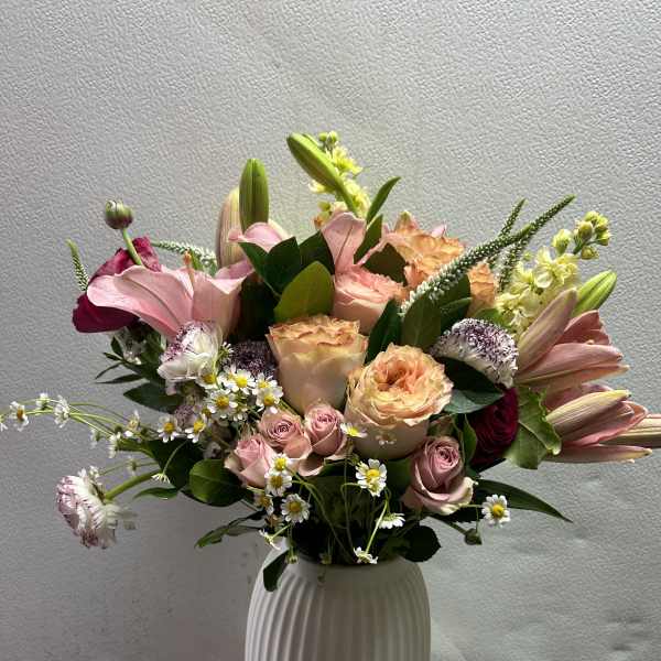 Mixed pink and peach bouquet in a white vase