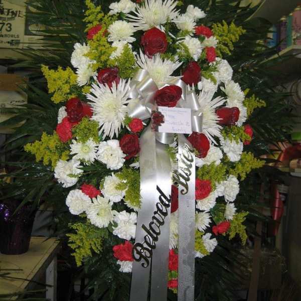 Standing funeral wreath with red and white flowers and silver ribbons