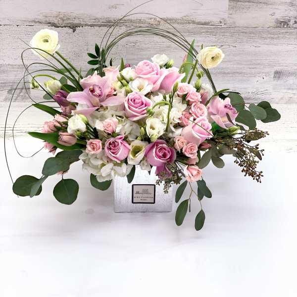 Pink and white floral arrangement in a square white vase