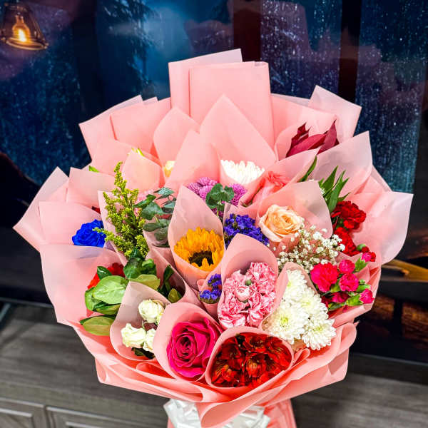 Mixed bouquet wrapped in pink paper with roses and chrysanthemums