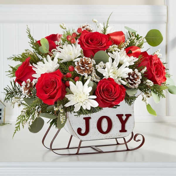 Red roses and white daisies in a JOY sleigh container