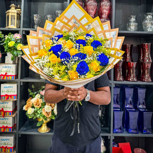Bouquet of blue and yellow roses wrapped in layered paper