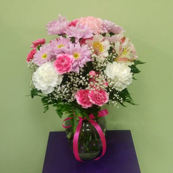 Pink and white mixed bouquet in a glass vase with a ribbon