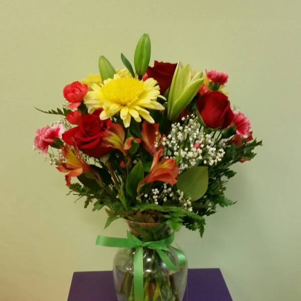 Mixed bouquet of red and yellow flowers in a glass vase