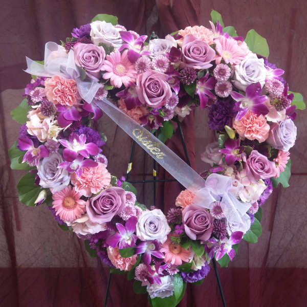 Heart-shaped floral wreath with pink and purple roses, orchids, and daisies