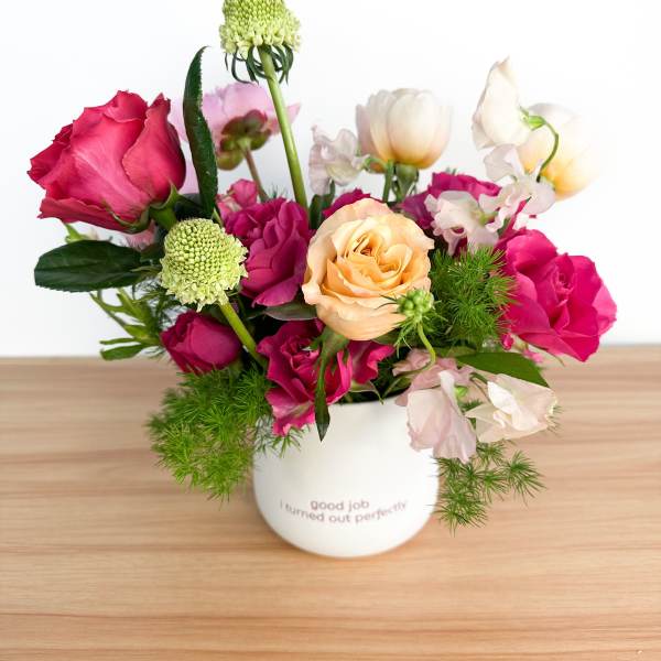 Mixed pink and peach roses in a white mug vase