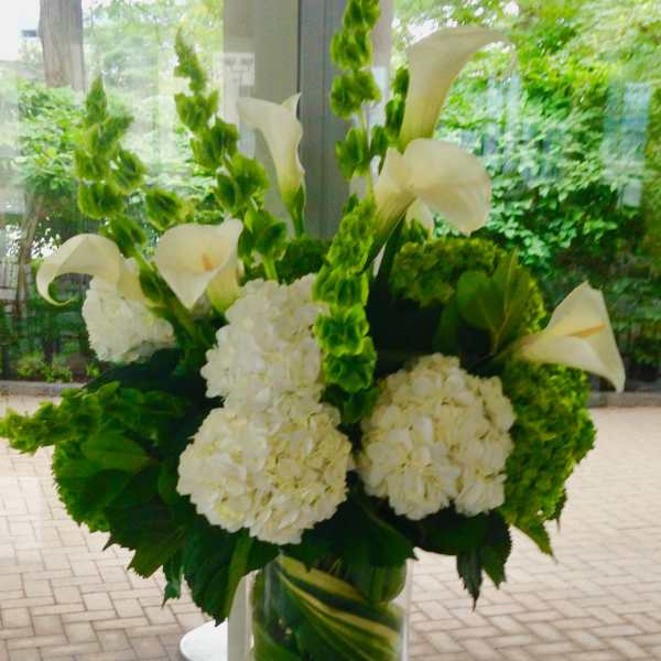 White calla lilies and hydrangeas in a glass vase