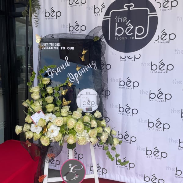 Large floral stand with cream roses and white orchids on a black display board