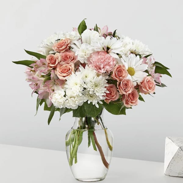 Pink roses and white daisies in a clear glass vase