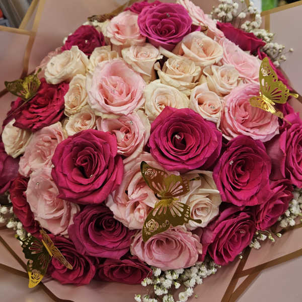 Bouquet of pink and cream roses with gold butterfly accents