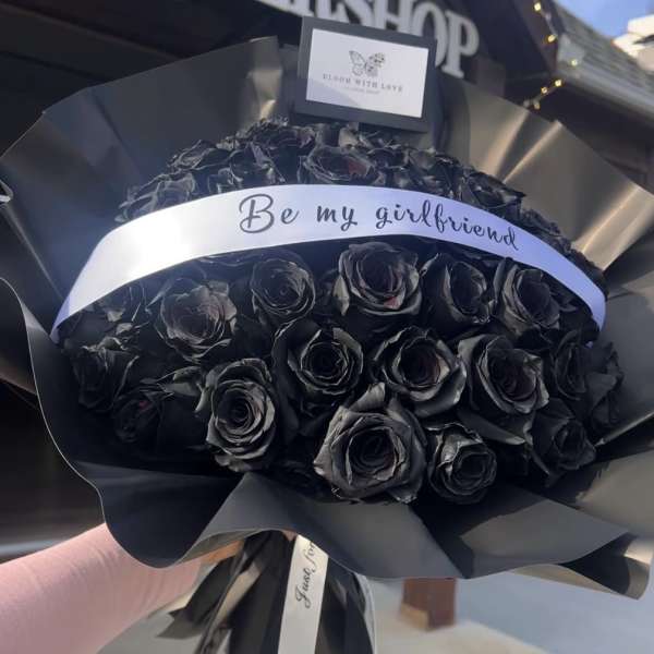 Black rose bouquet wrapped in black paper with a "Be my girlfriend" ribbon