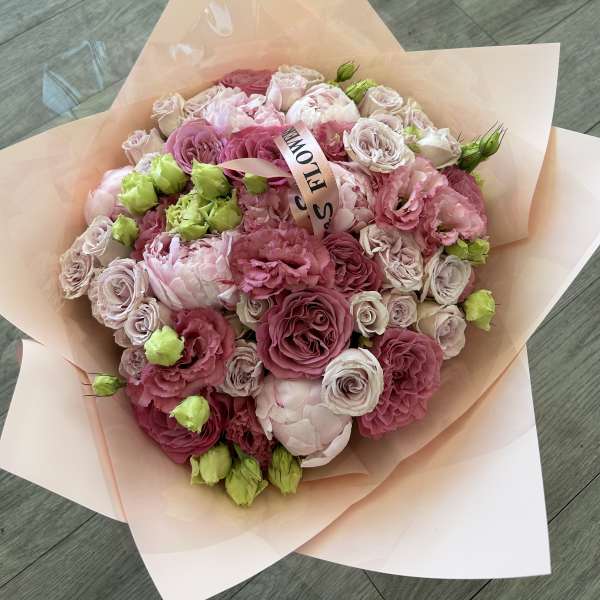 Pink and blush bouquet of roses and lisianthus wrapped in peach paper