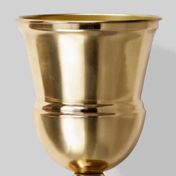 Gold metal urn vase on a plain background
