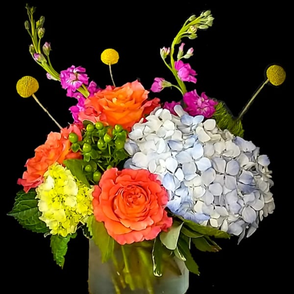 Colorful bouquet with roses and hydrangeas in a glass vase