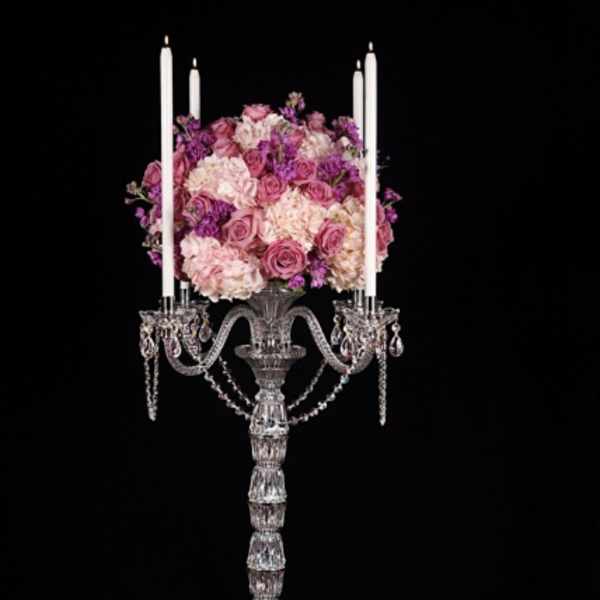 Pink and purple floral arrangement on a tall crystal candelabra.