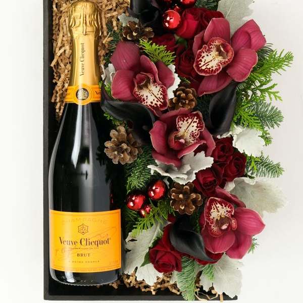 Gift box with a champagne bottle and red floral arrangement