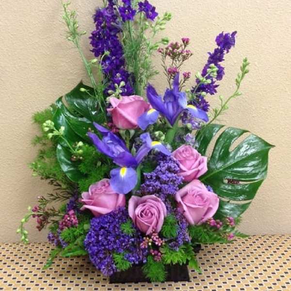 Purple and pink floral arrangement with roses and iris