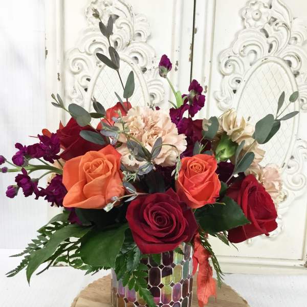 Mixed bouquet of roses and carnations in a mosaic vase