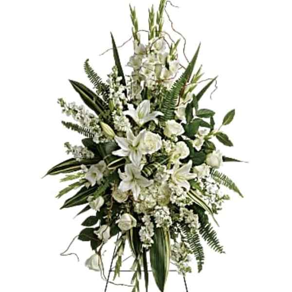 White floral standing spray on an easel with lilies and roses