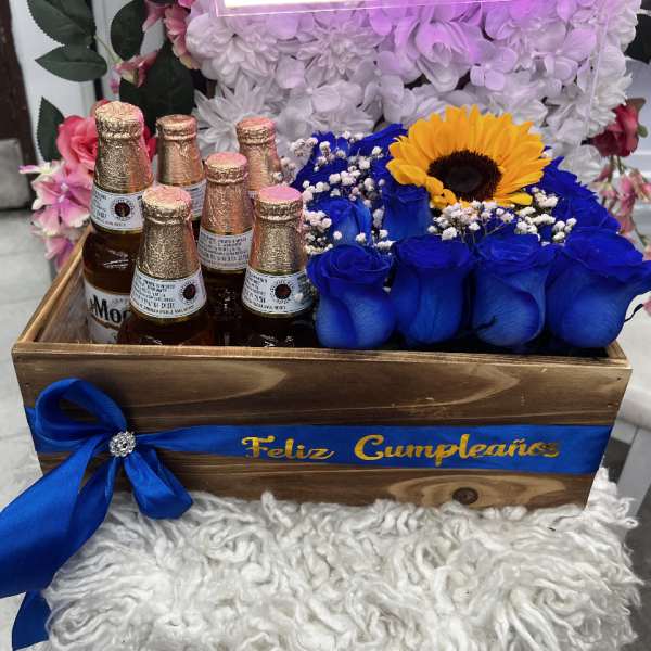 Wooden gift crate with blue roses, a sunflower, and beer bottles