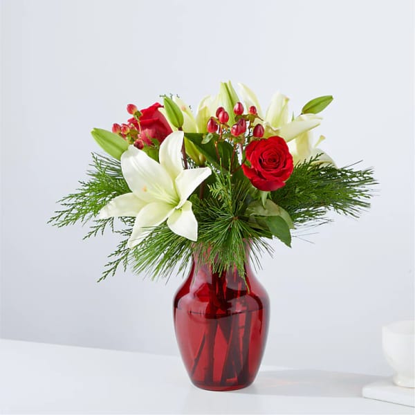 Red roses and white lilies in a red glass vase