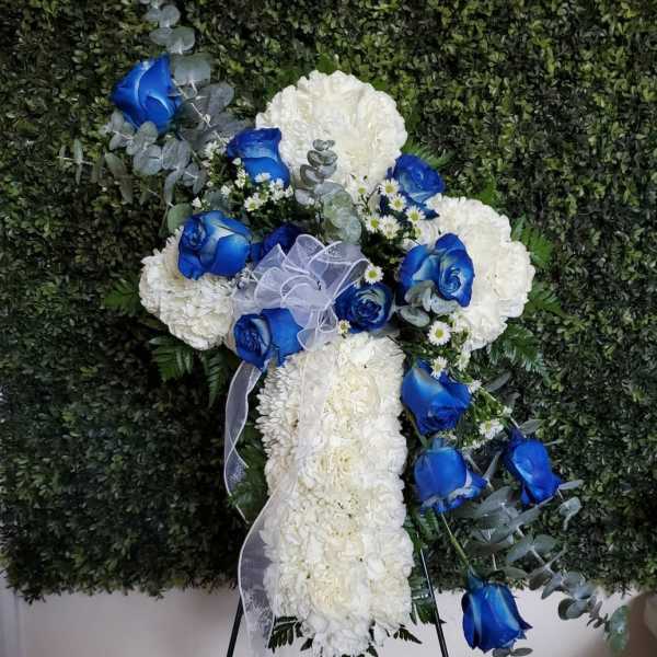 White floral standing spray with blue roses and ribbon