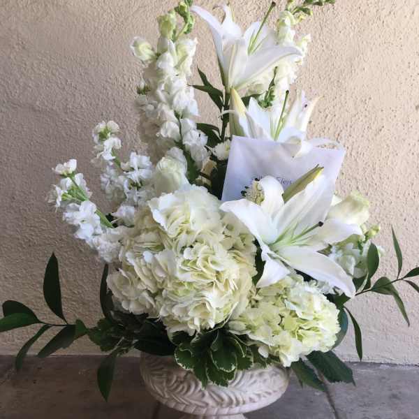 White lilies and hydrangeas in a pedestal vase