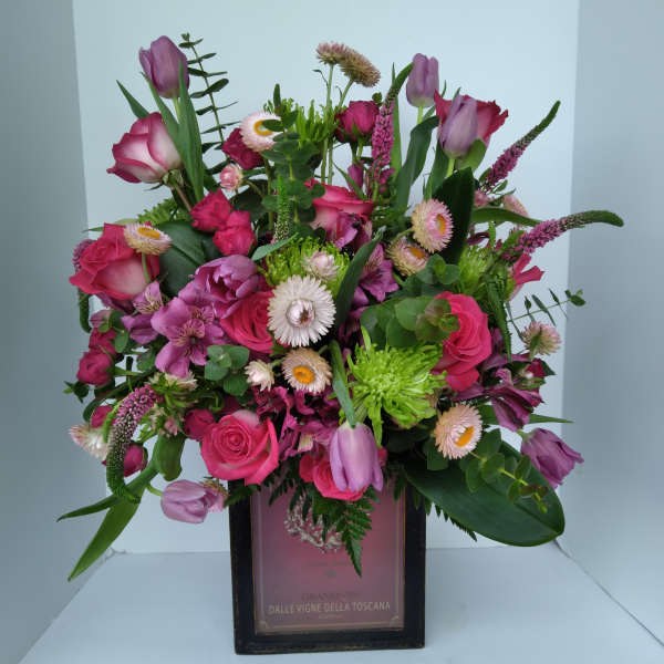 Mixed pink and purple bouquet in a square box