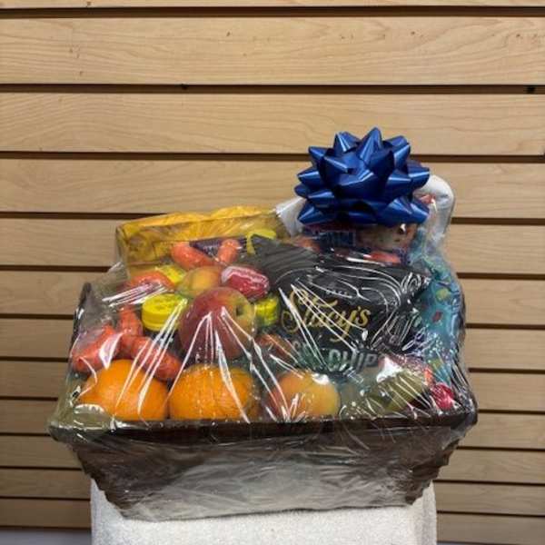 Gift basket of fruit and snacks wrapped in clear cellophane with a blue bow