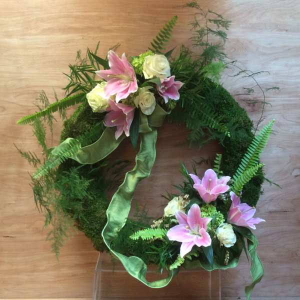 Green wreath with pink lilies and white roses