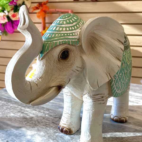 Decorative carved elephant figurine with green painted accents