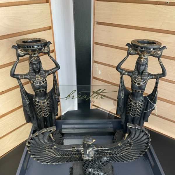 Decorative Egyptian-style statues with a winged bird sculpture in a display tray