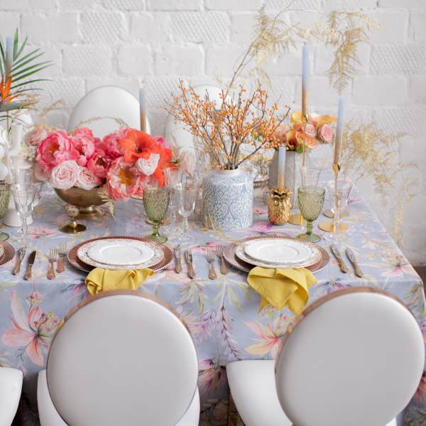 Floral table centerpiece with pink and orange flowers on a decorated dining table