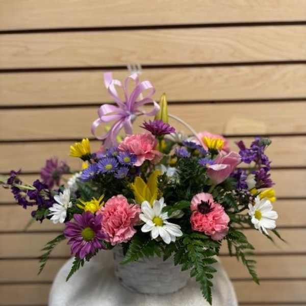 Mixed bouquet in a white basket with a lavender ribbon