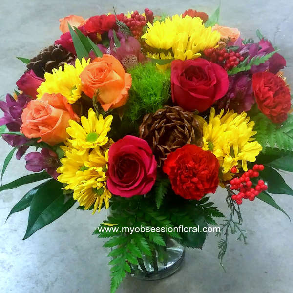 Mixed bouquet of roses and yellow daisies in a glass vase