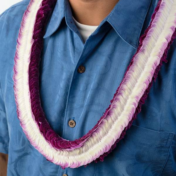 Purple and white flower lei worn over a blue button-up shirt