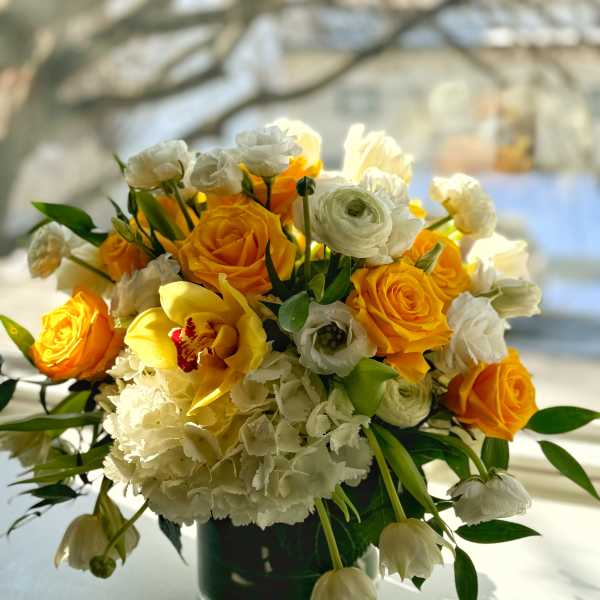 Yellow and white flower arrangement in a dark vase