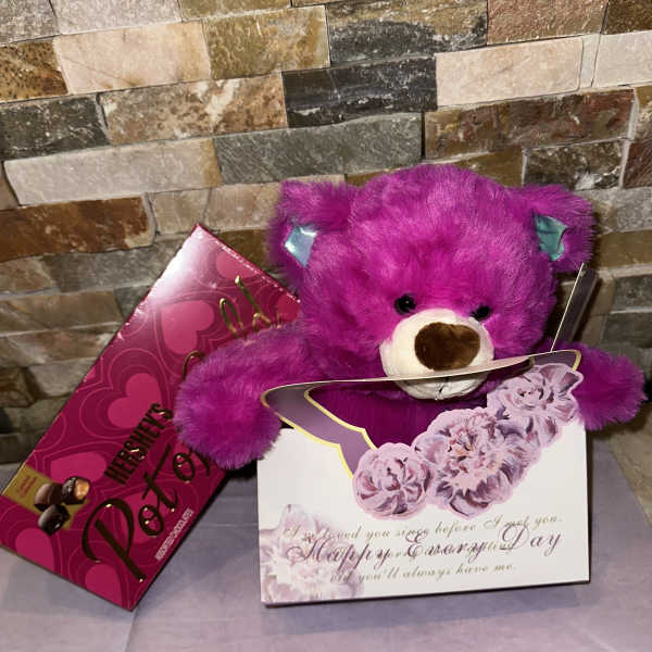 Purple teddy bear with a pink candy box and floral greeting card