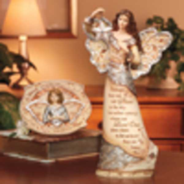 Two angel figurines with a framed angel plaque on a table.