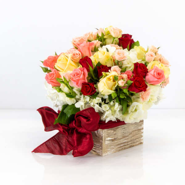 Mixed roses in a wooden box with a red ribbon