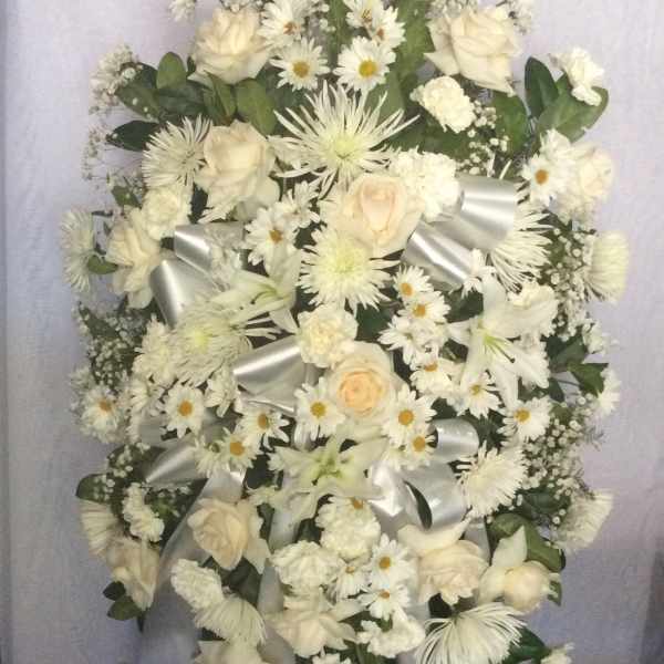 White floral standing spray with roses, daisies, and lilies