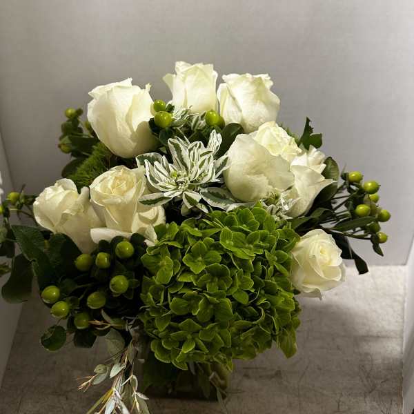 White roses and green hydrangea in a compact bouquet