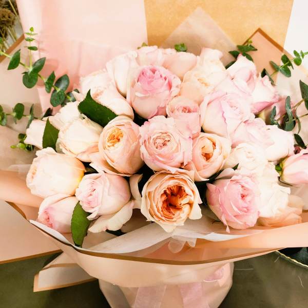 Bouquet of pale pink roses wrapped in blush paper