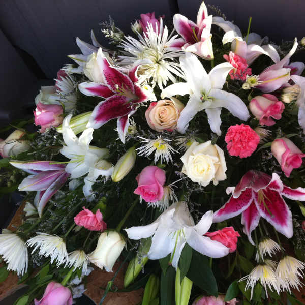 Large floral spray with white lilies, pink roses, and carnations